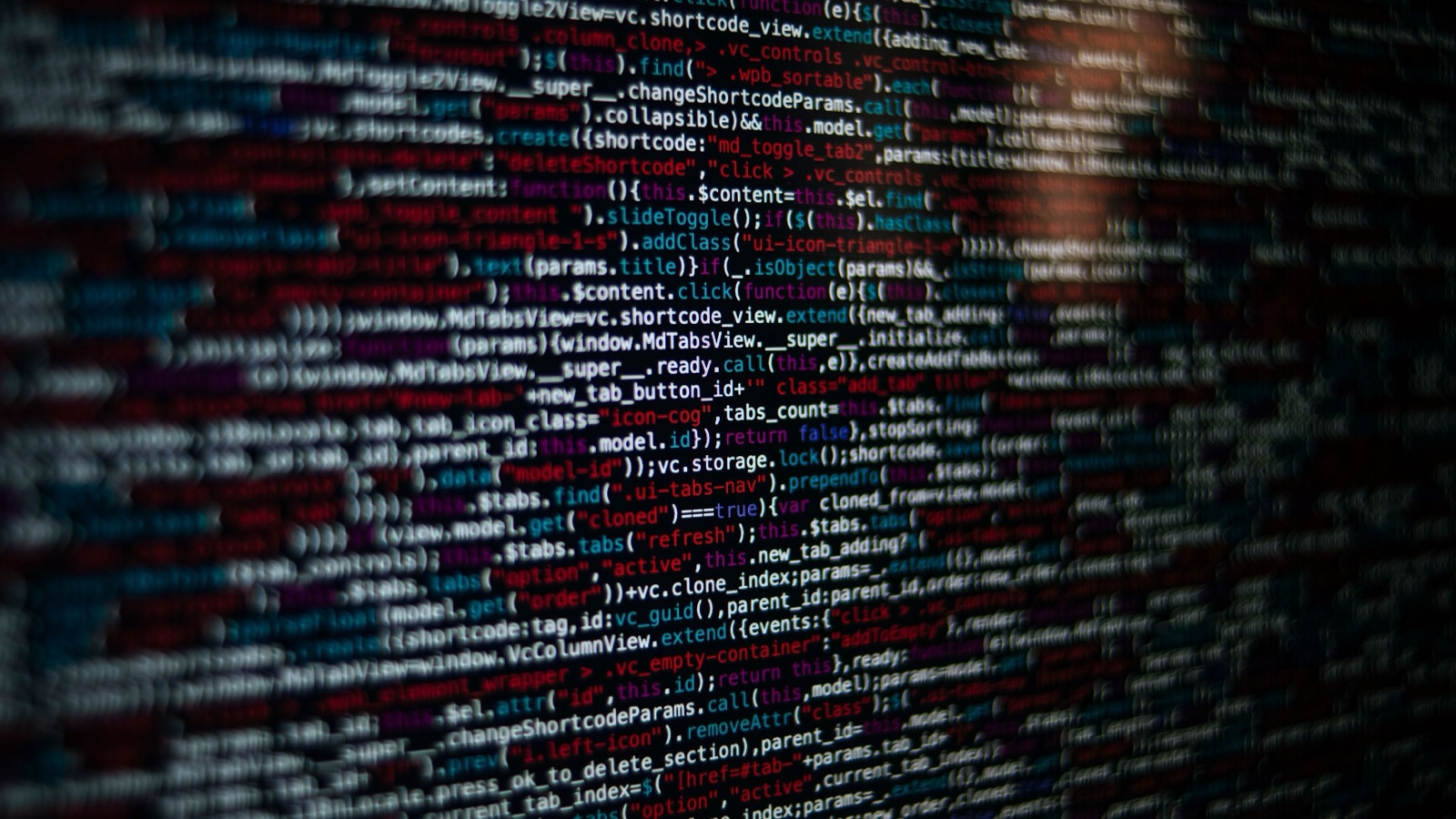 暗い画面に表示された大量のプログラムコード